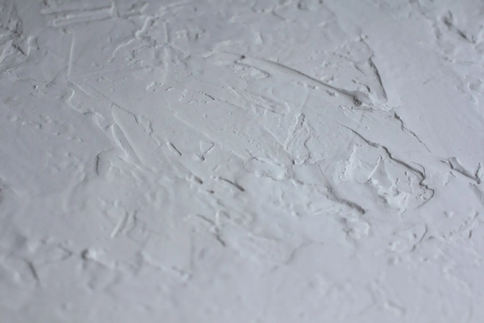 An uneven plaster surface part way through being flattened