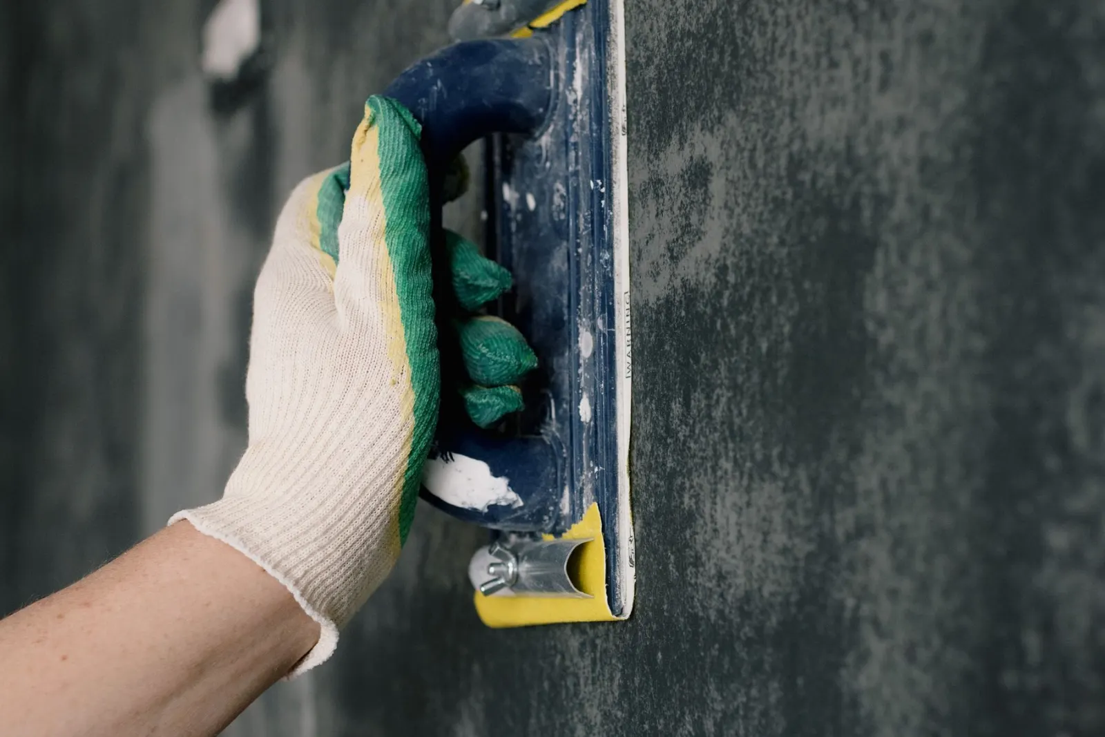 Working at a wall with a scraper before filling